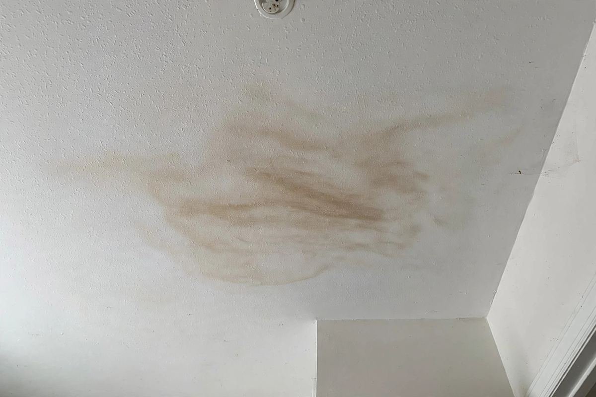 Faint water stain on a ceiling below a bathroom